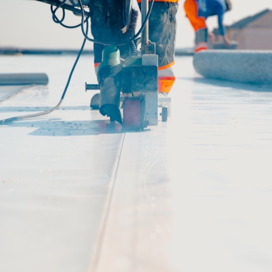 flat roof coating being applied to a flat roof
